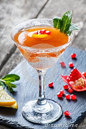 Fresh fruit red cocktail with mint, pomegranate, lemon in glass on wooden background. Summer drinks and alcoholic cocktails Stock Photo