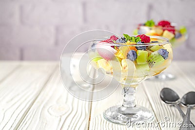 Fresh fruit salad on a light wooden table background Stock Photo