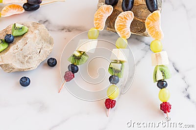 Fresh fruit on skewers, composition on stones. summer dessert Stock Photo