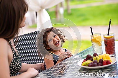 Mom and daughter having fruits and looking happy Stock Photo