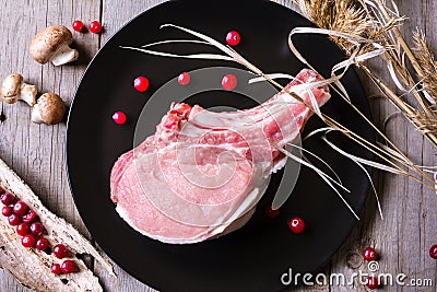 Fresh game meat on black plate and wooden table Stock Photo