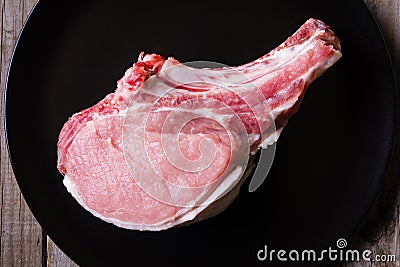 Fresh game meat on black plate and wooden table Stock Photo