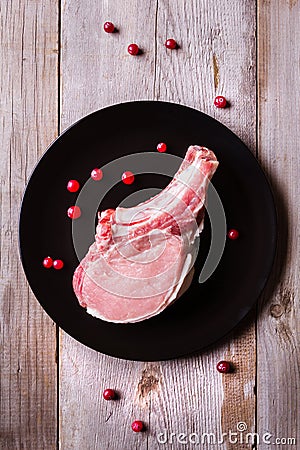 Fresh game meat on black plate and wooden table Stock Photo