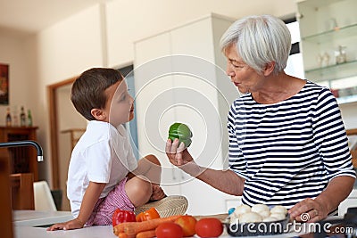 Fresh from grandmas garden. a grandmother preparing dinner with her grandchild in a kitchen. Stock Photo