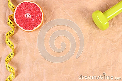Fresh grapefruit, tape measure and dumbbells for fitness, healthy lifestyles concept Stock Photo