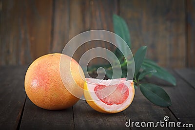 Fresh grapefruits with leaves on wooden background Stock Photo