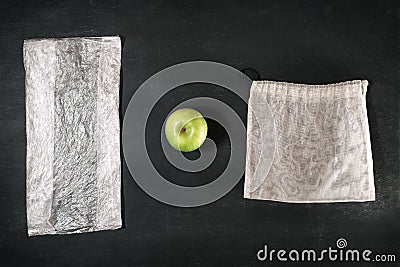 Fresh green apple between plastic package and eco grocery mesh, comparison of disposable and reusable packages Stock Photo