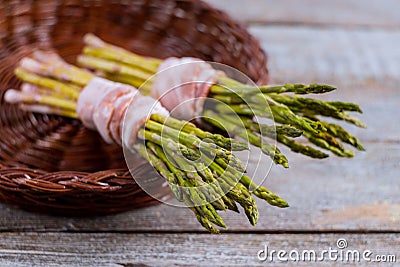 Fresh green asparagus wrapped with bacon in the basket Stock Photo