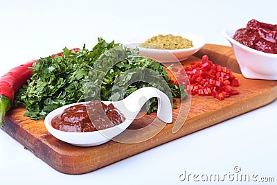 Fresh green cilantro, coriander leaves, tomato paste, chili pepper and spices on a wooden board. Ingredients for meat Stock Photo