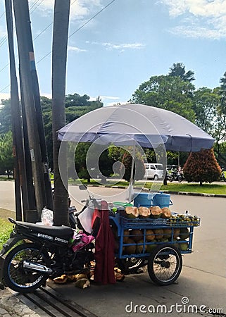 fresh green coconut seller with motorbike Editorial Stock Photo