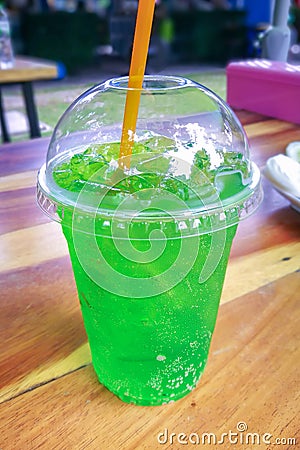 Fresh green cola water and ice in plastic glass. Stock Photo