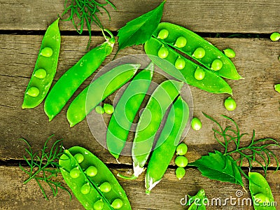 Fresh green peas on wood background. peas, pods and leaves set. Healthy food. Macro shooting. Stock Photo