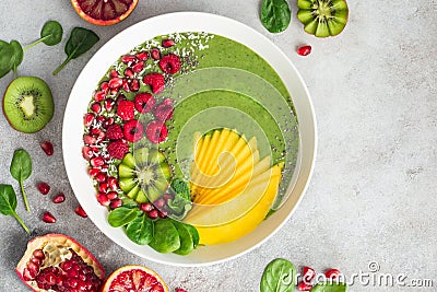 fresh green smoothie bowl with spinach, mango, kiwi and raspberry. Healthy vegan raw food Stock Photo