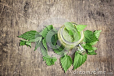 Fresh green smoothie with wild nettle and other herbs in mason jar. Stock Photo