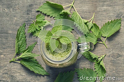 Fresh green smoothie with wild nettle and other herbs in mason jar. Stock Photo