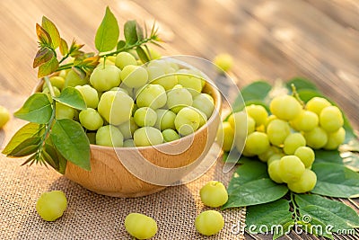 Fresh green star gooseberry (tropical Thai fruit) in bowl on wooden plank background Stock Photo