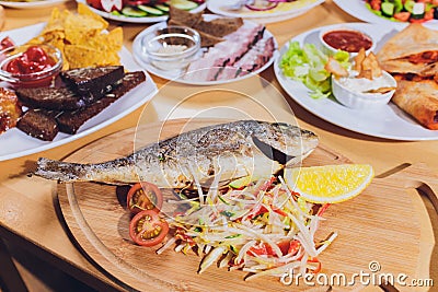 Fresh Grilled Dorado with Lemon and Cherry Tomatoes. Whole Bbq Sea Bream Fish Top View and Flat Lay. Sparus Aurata. Stock Photo