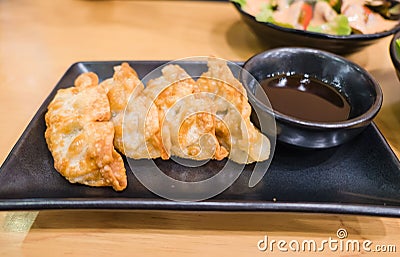 Fresh Gyoza on black plate . Homemade Asian with sauce Stock Photo