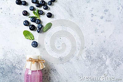 Fresh healthy blueberries smoothie berries and mint in glass jar on light white concrete background. Zero waste concept . Stock Photo