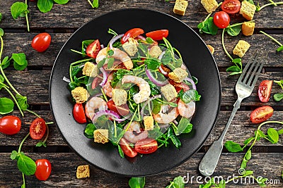 Fresh Healthy Prawns salad with tomatoes, red onion on black plate. concept healthy food Stock Photo