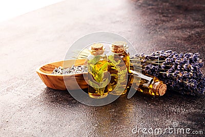 Fresh herbs from the garden and the different types of oils for massage and aromatherapy on table with lavender Stock Photo