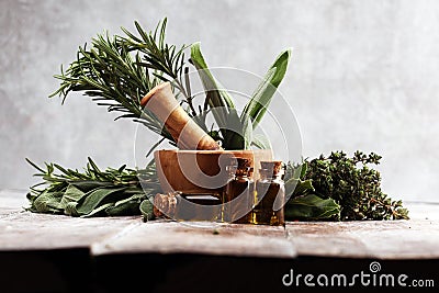 Fresh herbs from the garden and the different types of oils for massage and aromatherapy on table Stock Photo