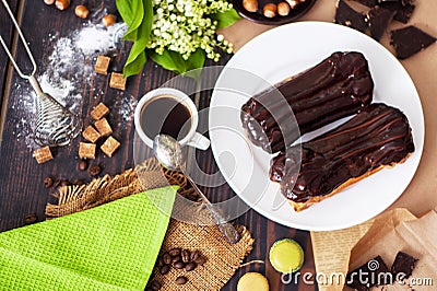 Fresh homemade eclairs with chocolate on the kitchen table. French pastries Stock Photo