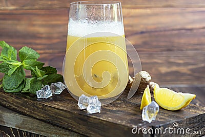 Fresh homemade ginger beer cocktail. Ice and lime on the table. On a wooden brownbackground. Stock Photo
