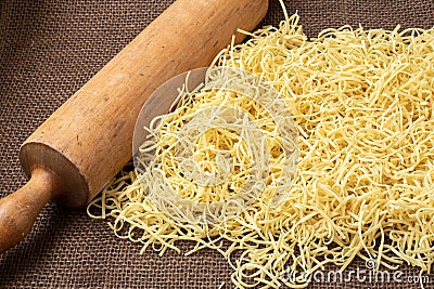 Fresh homemade noodles and wooden kitchen rolling pin Stock Photo