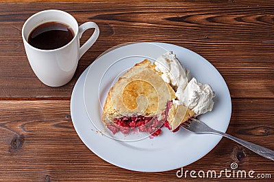 Fresh homemade pie with cherry pulp and ice cream on a plate. A slice of a cherry pie with a ruddy crust on a wooden table. Cherry Stock Photo