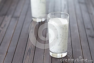 Fresh homemade yogurt kefir, ayran in glass with herbs. Ayran, homemade yogurt drink with herbs and cucumbers - healthy summer Stock Photo