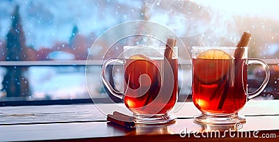 Fresh hot mulled wine on a wooden table at a ski resort. Winter Christmas holidays in an alpine hotel or restaurant or cafe. Snowy Stock Photo