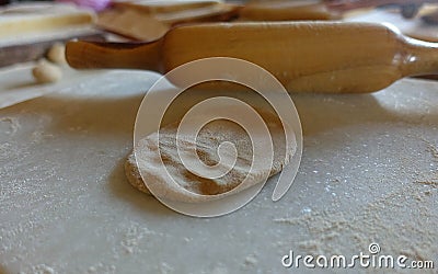 Fresh Indian roti dough next to rolling pin Stock Photo