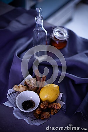 Fresh ingredients for turmeric tea. Turmeric root, ginger, lemon, cinnamon, black pepper corn, honey and coconut oil. Stock Photo