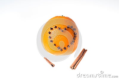 Fresh juicy bright orange decorated with a heart of cloves and vanilla sticks on a white background. Stock Photo