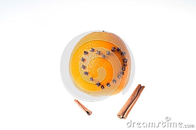 Fresh juicy bright orange decorated with a heart of cloves and vanilla sticks on a white background. Stock Photo