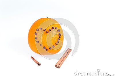Fresh juicy bright orange decorated with a heart of cloves and vanilla sticks on a white background. Stock Photo