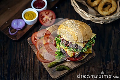 Fresh and juicy hamburger. Cheese burger with beef or bacon, patty tomato, onion ring and tomato sauce or ketchup Stock Photo