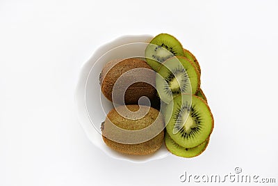 Fresh and juicy kiwi fruit, chopped and whole on a white plate. Delicious fruits and pieces of green kiwi Stock Photo