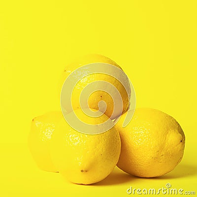 Fresh juicy lemon slides on a bright yellow background. Concept minimalism. Square frame Copy space. Stock Photo