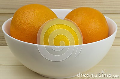 Fresh juicy natural apples and oranges in a shiny white plate on wooden background Stock Photo