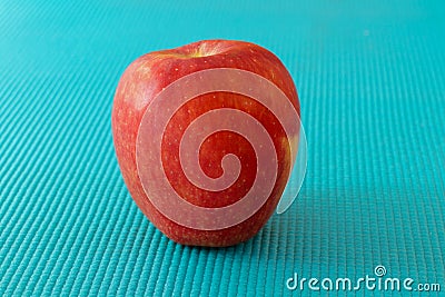 Red apple on sky blue texture surface Stock Photo