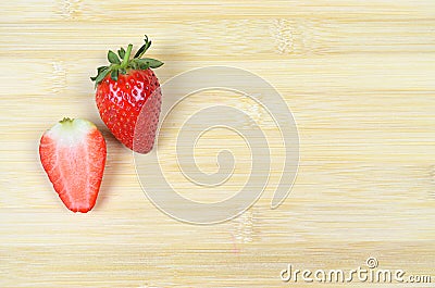 Fresh Juicy Strawberry and a slice cut isolated on wood background Stock Photo