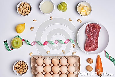 Fresh keto food and measuring tape on white background. Top view Stock Photo