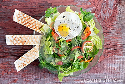 Fresh leafy green mixed salad with a fried egg Stock Photo