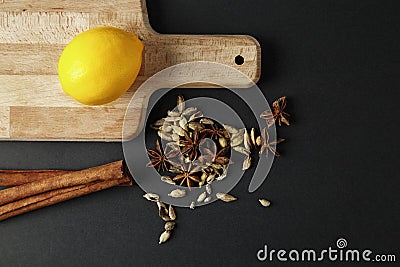 Fresh lemon at cutting board with mixed spice, cinnamon sticks. Stock Photo