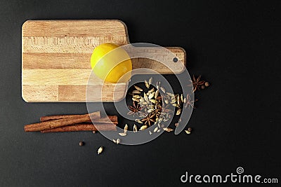 Fresh lemon at cutting board with mixed spice, cinnamon sticks. Stock Photo