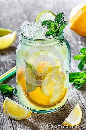 Fresh lemonade with mint, lemon and ice in glass jar on wooden background. Summer drinks and cocktails Stock Photo