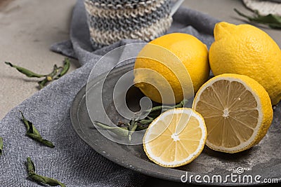 Fresh lemons and lemons leaves on rustic plate. Fresh citrus fruit background. Stock Photo