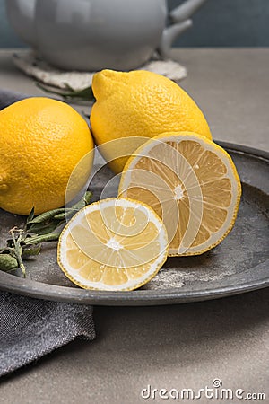 Fresh lemons and lemons leaves on rustic plate. Fresh citrus fruit background Stock Photo